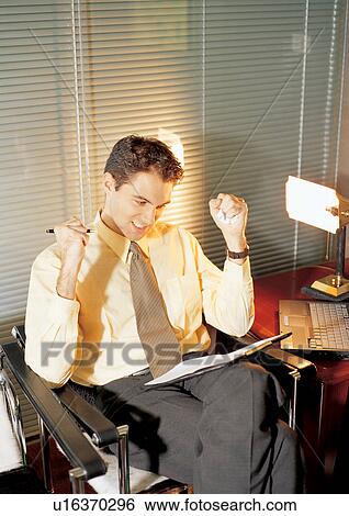 Stock Photograph - business, business executive, office papers, clenching teeth, lamp, achievement. Fotosearch