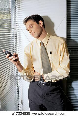 Stock Photo - leaning by wall, profession, communication, standing, career. Fotosearch
