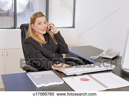 Stock Photography - looking away, mobile phone, occupation, business executive, computer, connectivity, office table. Fotosearch
