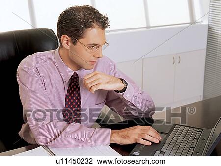 Stock Image - office chair, button down shirt, occupation, business executive, using laptop, professional, tie. Fotosearch