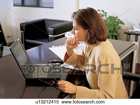 Stock Photography - suit, woman only, lifestyle, hand on chin, business. Fotosearch