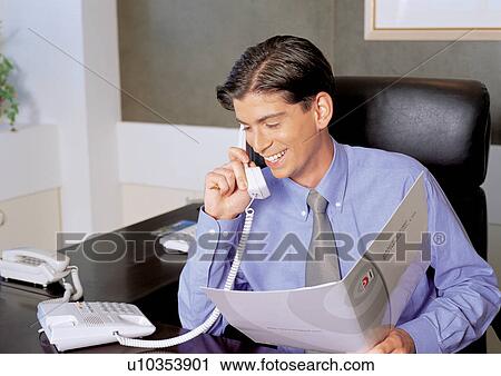 Stock Image - telephone receiver, holding, office table, phone cord, office chair. Fotosearch
