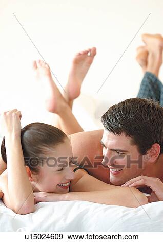 Stock Photo - Couple in bed laughing. Fotosearch
