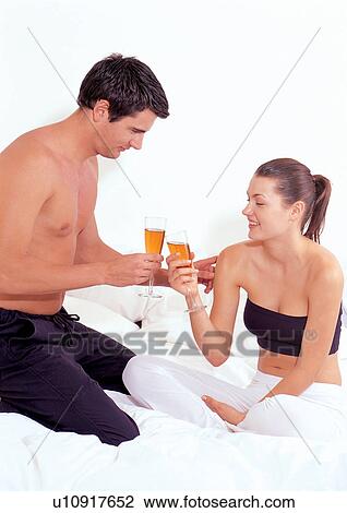 Stock Image - couples, clinking glasses, tossing, lifestyle, relaxation, kneeling. Fotosearch