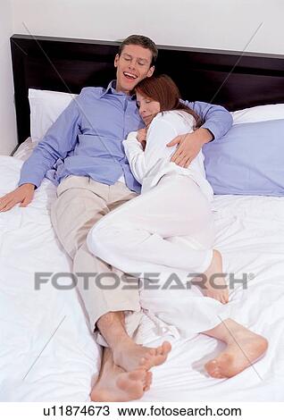 Stock Image - couples, lying down, indoor. Fotosearch