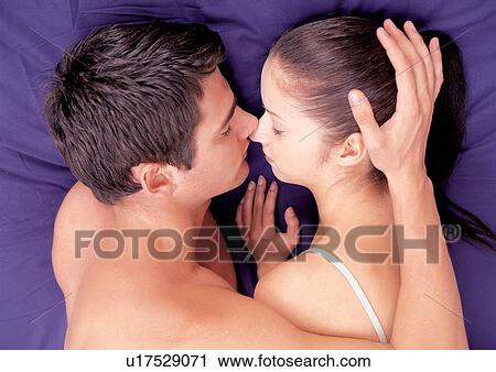 Stock Image - couples, lying down, indoor. Fotosearch