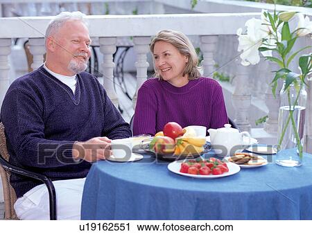 Stock Image - couples, sitting, outdoor. Fotosearch