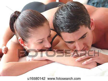 Stock Image - leaning, young adult, smiling, ponytail, romance, cheerful, affection. Fotosearch