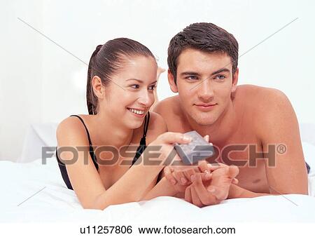 Stock Photograph - two people, holding hands, carefree, toothy smile, smiling, lifestyle. Fotosearch