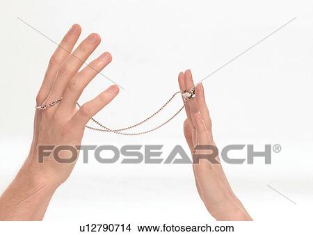 Close-up of a gold chain in a young couple's hands View Large Photo Image Picture - Close-up of a gold chain in a young couple's hands. Fotosearch