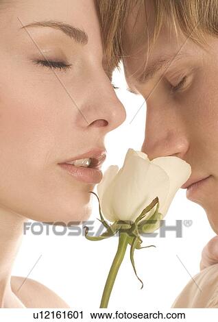 Stock Image - Close-up of a young couple smelling a rose. Fotosearch