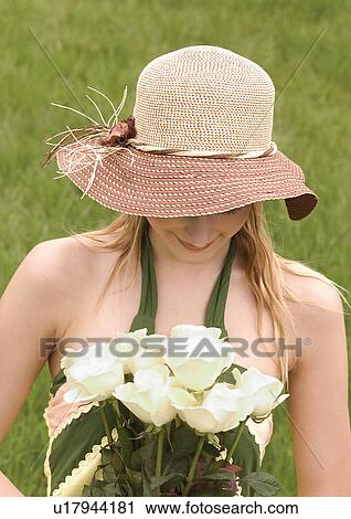 Stock Image - Close-up of a young woman holding a bouquet of white roses. Fotosearch