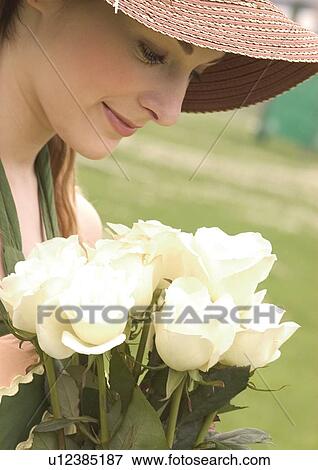 Stock Photo - Close-up of a young woman holding a bouquet of white roses. Fotosearch