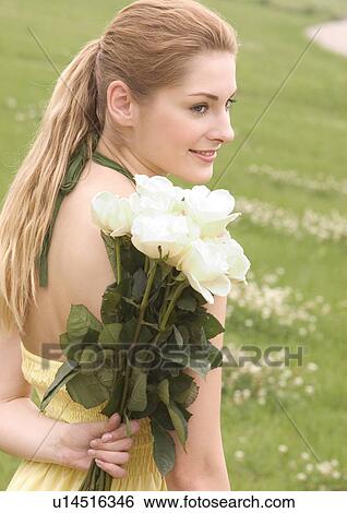 Close-up of a young woman holding a bouquet of white roses View Large Photo Image Stock Photograph - Close-up of a young woman holding a bouquet of white roses. Fotosearch