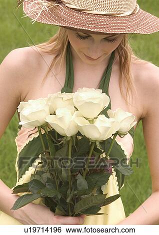 Close-up of a young woman holding a bouquet of white roses View Large Photo Image Stock Photograph - Close-up of a young woman holding a bouquet of white roses. Fotosearch