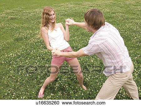 High angle view of a young couple playfully wrestling in a lawn View Large Photo Image Stock Image - High angle view of a young couple playfully wrestling in a lawn. Fotosearch