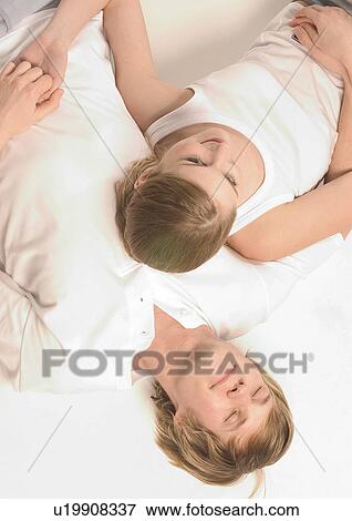 Stock Photo - High angle view of a young couple sleeping. Fotosearch