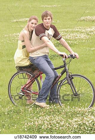 Portrait of a young couple sitting on a cycle View Large Photo Image Stock Photo - Portrait of a young couple sitting on a cycle. Fotosearch