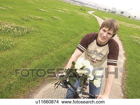 Portrait of a young man riding a cycle View Large Photo Image Picture - Portrait of a young man riding a cycle. Fotosearch
