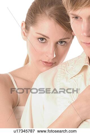 Stock Photo - Portrait of a young woman holding a young man from behind. Fotosearch