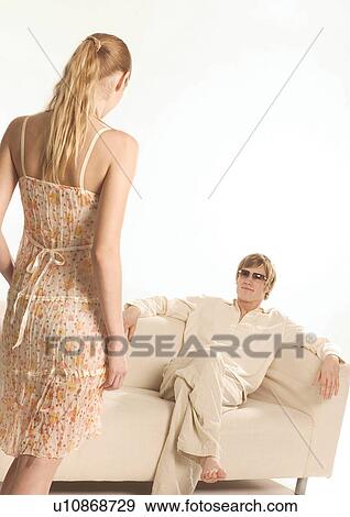 Stock Photo - Rear view of a young woman standing in front of a young man. Fotosearch