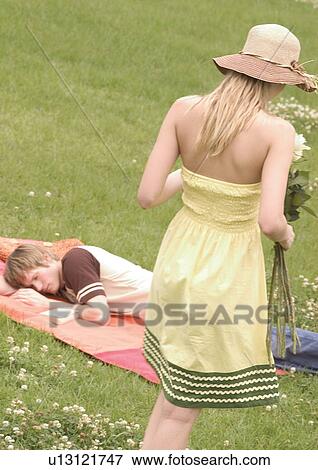 Rear view of a young woman standing in a lawn View Large Photo Image Stock Photo - Rear view of a young woman standing in a lawn. Fotosearch