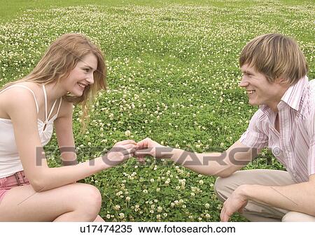 Stock Photography - Side profile of a young couple holding hands. Fotosearch