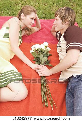 Side profile of a young couple lying face to face View Large Photo Image Stock Photo - Side profile of a young couple lying face to face. Fotosearch
