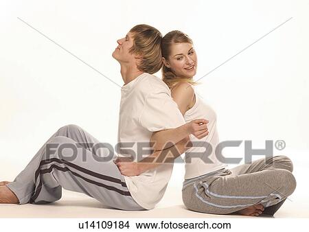 Picture - Side profile of a young couple sitting back to back. Fotosearch