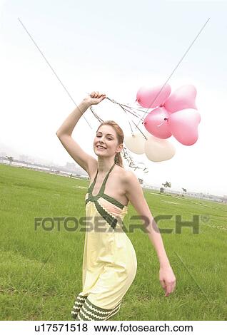 Young woman running with balloons in her hand View Large Photo Image Stock Photo - Young woman running with balloons in her hand. Fotosearch