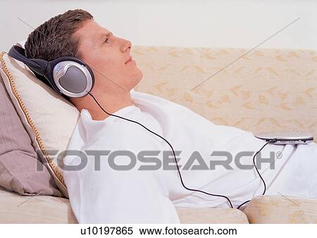 Stock Photography - enjoyment, indoor, lying down, personal compact disc player, head and shoulder. Fotosearch