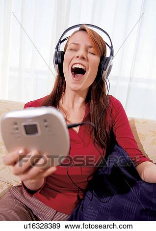 Stock Photo - gadget, brown hair, personal compact disc player, eyes closed, hobby, earphones. Fotosearch