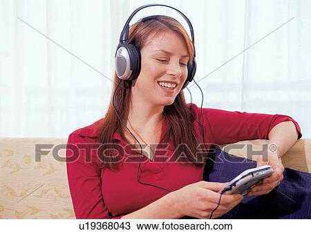 Stock Image - head and shoulder, happiness, personal compact disc player, smiling, youthful, music, enjoyment. Fotosearch