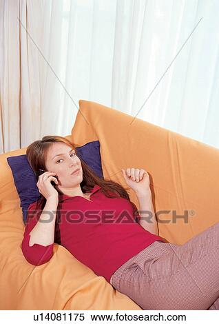 Stock Photography - lying down, cellular, leisure, sofa, indoor, day, cell. Fotosearch