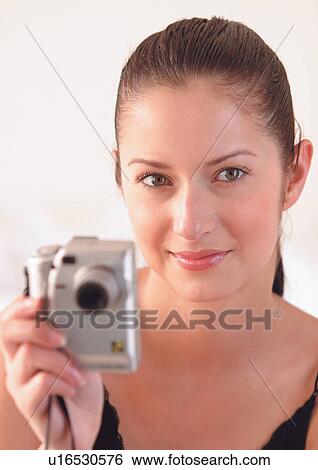 Stock Photograph - operating, brown hair, young, camera, device, viewing. Fotosearch