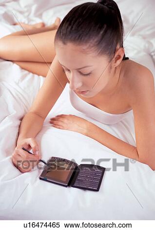 Stock Photography - relaxing, wrinkled, brown hair, cushion, bed sheet, bedroom, new generation. Fotosearch