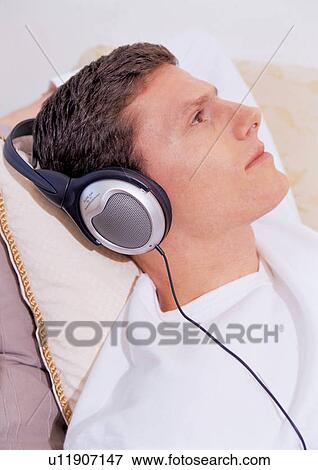 Stock Photo - resting, t-shirt, brown hair, sole, sofa. Fotosearch