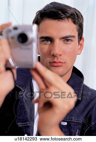 Stock Image - shooting, device, operating, young, clicking, single, youthful. Fotosearch