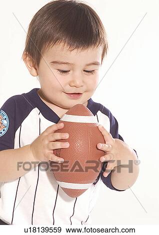 Stock Photo - Close-up of a boy holding a football. Fotosearch