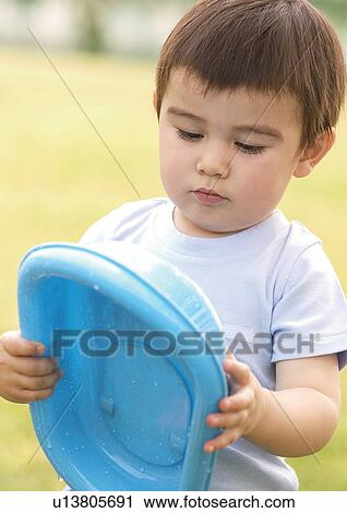 Close-up of a boy holding a plastic disc View Large Photo Image Stock Image - Close-up of a boy holding a plastic disc. Fotosearch