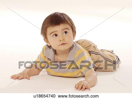 Close-up of a boy lying on his stomach View Large Photo Image Stock Image - Close-up of a boy lying on his stomach. Fotosearch