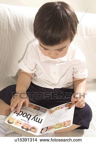 Picture - Close-up of a boy reading on a couch. Fotosearch