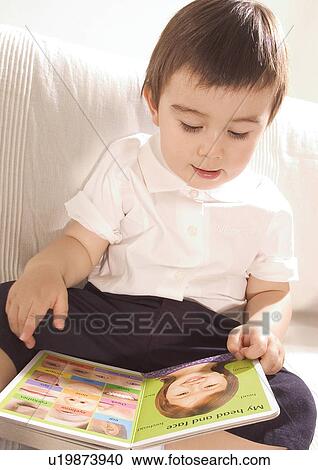 Close-up of a boy reading on a couch View Large Photo Image Stock Image - Close-up of a boy reading on a couch. Fotosearch