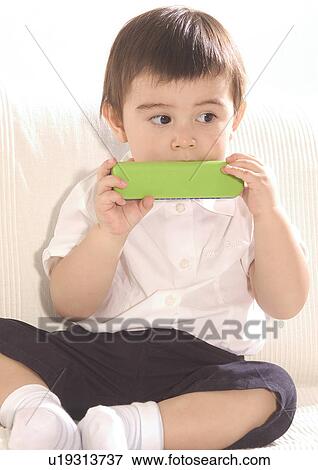Close-up of a boy sitting on a couch View Large Photo Image Stock Photo - Close-up of a boy sitting on a couch. Fotosearch