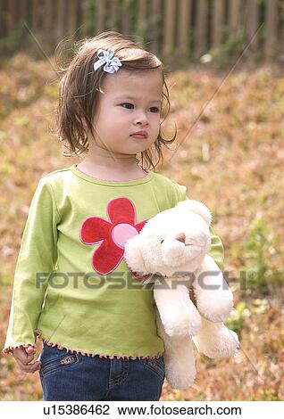 Stock Image - Close-up of a girl holding a stuffed toy. Fotosearch