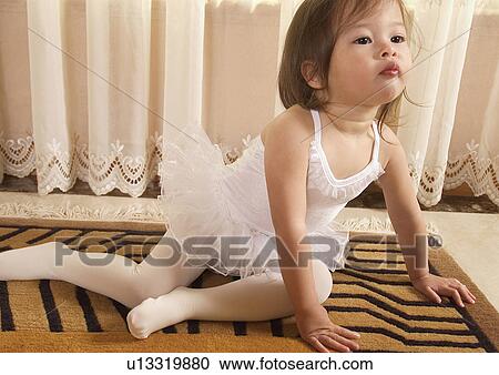 Stock Image - Close-up of a girl sitting on the floor in a tutu. Fotosearch