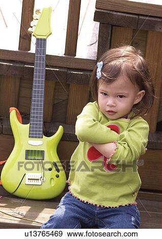 Stock Photo - Close-up of a girl sitting with her arms crossed. Fotosearch