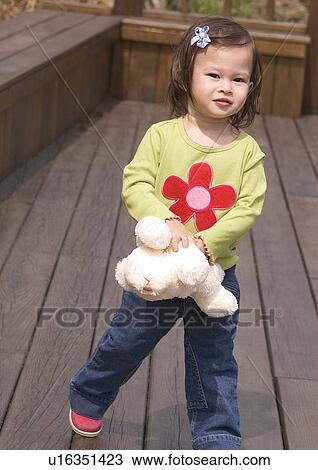 Stock Image - Portrait of a girl hugging a stuffed toy. Fotosearch