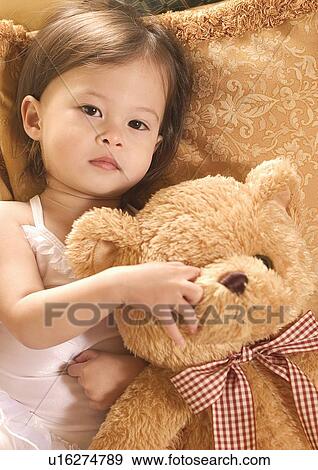 Portrait of a girl hugging a teddy bear View Large Photo Image Stock Photo - Portrait of a girl hugging a teddy bear. Fotosearch