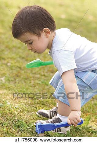 Side profile of a boy bending down View Large Photo Image Stock Photo - Side profile of a boy bending down. Fotosearch